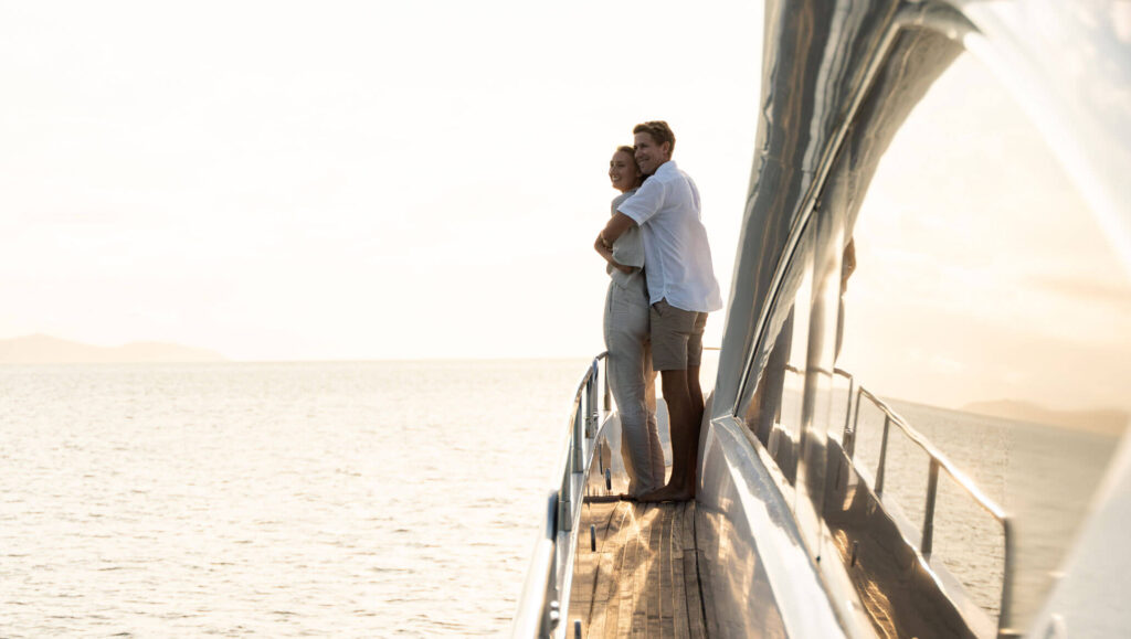 Guests on the side deck of M/Y ALANI in the late-afternoon light